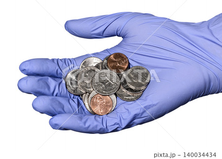 Hand in a blue latex glove with heap of American coins Hand in a blue latex glove with heap of American coins 140034434