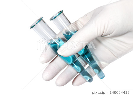 Hand in a medical latex glove holds two test tubes with a blue liquid Hand in a medical latex glove holds two test tubes with a blue liquid 140034435