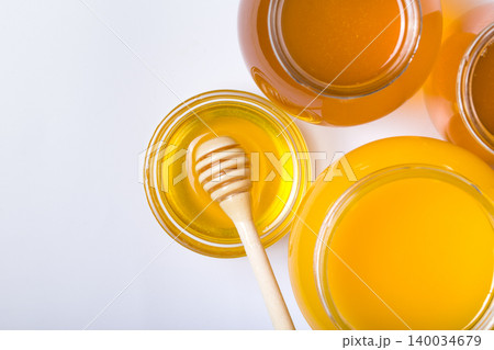 honey dipper and honey in jar on white background honey dipper and honey in jar on white background 140034679