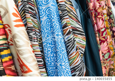 Bright patterned Uzbek fabrics and textiles hang closely 140035855