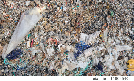 Plastic waste and microplastics cover the beach, causing severe ecological damage to marine life and coastlines 140036402