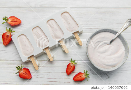 Homemade strawberry yogurt popsicles chilling in mold Homemade strawberry yogurt popsicles chilling in mold 140037092