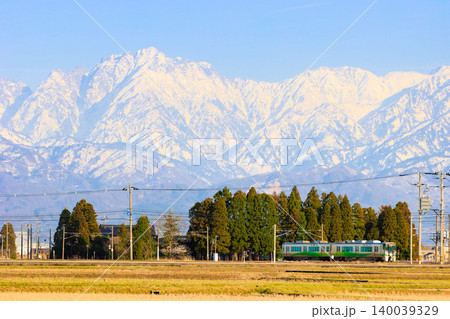 残雪の立山連峰を背景に早春の富山を走るあいの風とやま鉄道521系電車の雄大な風景 残雪の立山連峰を背景に早春の富山を走るあいの風とやま鉄道521系電車の雄大な風景 140039329