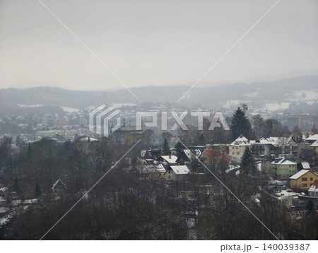Softly blurred valley with scattered homes and leafless trees illustrates peaceful winter solitude Softly blurred valley with scattered homes and leafless trees illustrates peaceful winter solitude 140039387