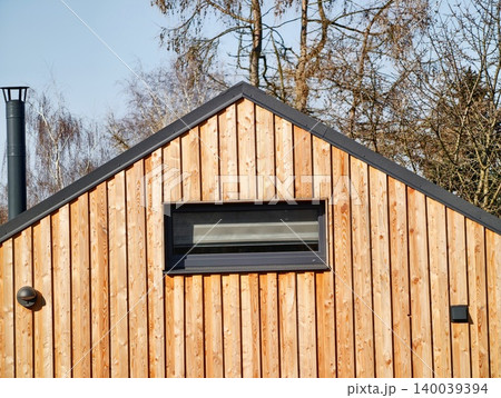 Rustic wooden dwelling with scenic surroundings. Ecofriendly tiny residence nestled among lush deciduous trees 140039394