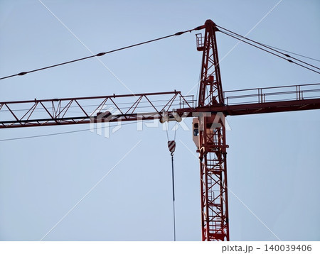 Red crane cables with tensioned hardware details. Close view of crane jib with pulley system against sky Red crane cables with tensioned hardware details. Close view of crane jib with pulley system against sky 140039406