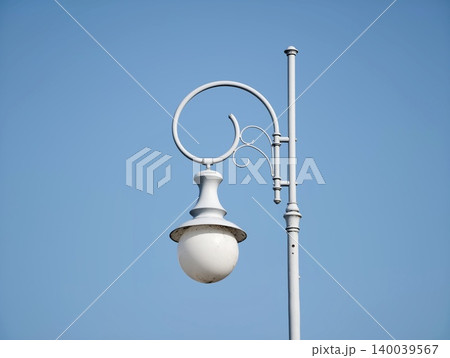 Decorative light against blue sky. Stylish lamp with detailed features against bright daytime sky Decorative light against blue sky. Stylish lamp with detailed features against bright daytime sky 140039567