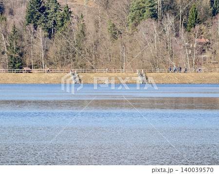 Tranquil lakeside with natural features. Calm water setting with shoreline steps and surrounding vegetation 140039570