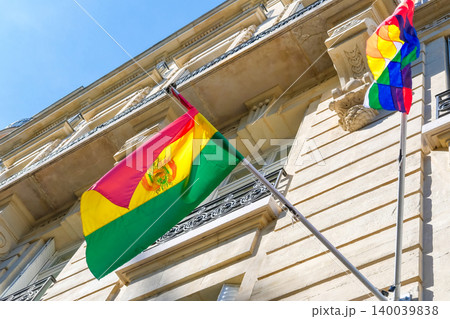 Bolivian flag swaying in the wind against blue sky and historical buildings. Bolivia and Wiphala flags. Flag day celebration concept, patriotism concept. Embassies and consulates of countries 140039838