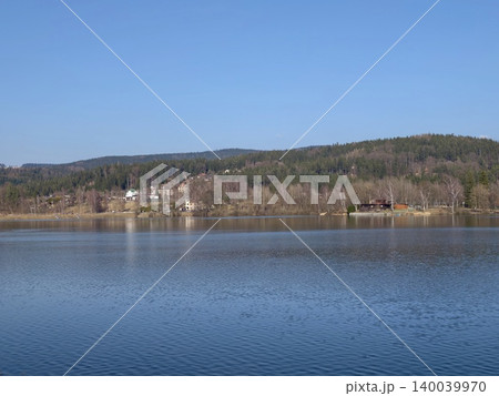 Expansive water and mountain vista. Calm waters reflect sky and distant mountain range scenery 140039970