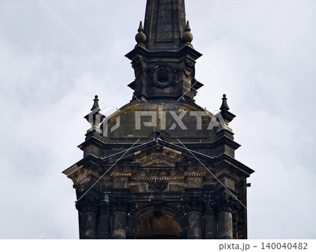 Decorative Gothic Tower. Detailed Baroque Steeple Set Against Overcast Sky with Conservation Elements Decorative Gothic Tower. Detailed Baroque Steeple Set Against Overcast Sky with Conservation Elements 140040482