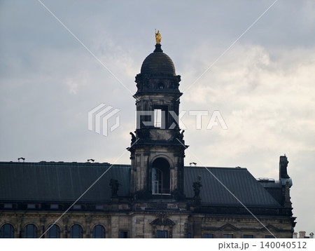 Silhouette of tower and buildings against stormy sky highlighting composition and atmospheric depth Silhouette of tower and buildings against stormy sky highlighting composition and atmospheric depth 140040512