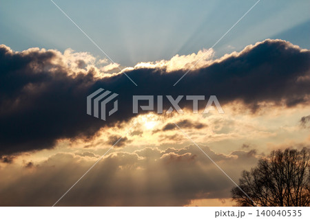 Gorgeous sunbeams burst through a dramatic sky, casting brilliant rays amid dark, fluffy clouds. A captivating natural spectacle unfolds Gorgeous sunbeams burst through a dramatic sky, casting brilliant rays amid dark, fluffy clouds. A captivating natural spectacle unfolds 140040535