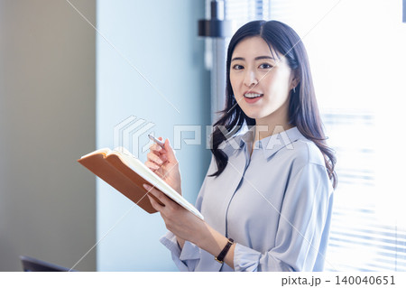 手帳とペンを持って微笑む女性 手帳とペンを持って微笑む女性 140040651
