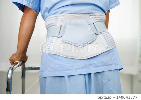 Asian senior pain back wearing elastic support belt with walker. Asian senior pain back wearing elastic support belt with walker. 140041377