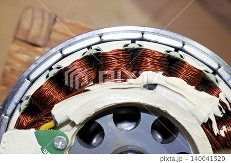 Disassembled electric bicycle gear motor showing detailed copper wire stator windings and internal mechanism, mechanical repair close-up shot focused on industrial components Disassembled electric bicycle gear motor showing detailed copper wire stator windings and internal mechanism, mechanical repair close-up shot focused on industrial components 140041520
