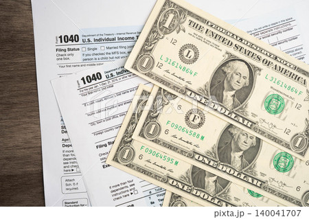 Tax form 1040 U.S. Individual Income Tax Return with dollar banknotes money. Tax form 1040 U.S. Individual Income Tax Return with dollar banknotes money. 140041707