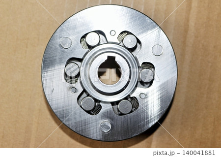 Cleaned sprag clutch component of an e-bike geared motor hub featuring metal rollers and springs, top-down studio shot against a cardboard background for technical repair documentation Cleaned sprag clutch component of an e-bike geared motor hub featuring metal rollers and springs, top-down studio shot against a cardboard background for technical repair documentation 140041881