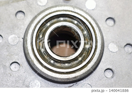 Close-up of an electric bicycle motor ball bearing with fresh lubricant applied after removing the protective seal during maintenance and repair procedure Close-up of an electric bicycle motor ball bearing with fresh lubricant applied after removing the protective seal during maintenance and repair procedure 140041886