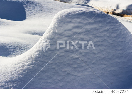 Pristine white snowdrifts sparkle in bright winter sunlight, creating fascinating patterns of blue shadow and soft, rolling texture across the frosty landscape Pristine white snowdrifts sparkle in bright winter sunlight, creating fascinating patterns of blue shadow and soft, rolling texture across the frosty landscape 140042224
