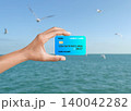 hand hold blue credit card isolated on blur ocean 140042282