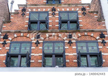 Colorful shutters at the windows of an old house. Typical Dutch. In the background the famous town hall of Veere, Zeeland, The Netherlands 140042443