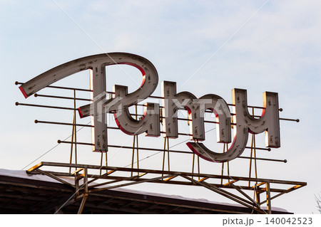 Weathered Soviet-era neon sign Rhythm club stands against a pale sky, showing vintage design and decay in Russia Weathered Soviet-era neon sign Rhythm club stands against a pale sky, showing vintage design and decay in Russia 140042523