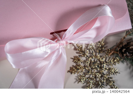 Beautiful gift pink cardboard box stars Christmas balls on beige background top view Flat lay. New Year presents Festive decorations 2024 celebration. Merry Christmas Happy Holidays card 140042564