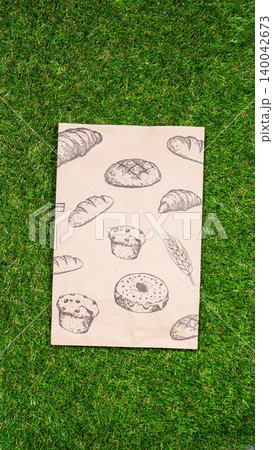 brown paper bag on Green Bush Trees Foliage Background. Eco Nature Friendly Style,Go to zero waste ecological shopping bag on the green grass. An alternative to disposable packages. Zero waste concept brown paper bag on Green Bush Trees Foliage Background. Eco Nature Friendly Style,Go to zero waste ecological shopping bag on the green grass. An alternative to disposable packages. Zero waste concept 140042673