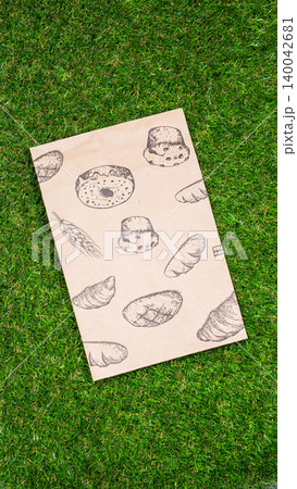 brown paper bag on Green Bush Trees Foliage Background. Eco Nature Friendly Style,Go to zero waste ecological shopping bag on the green grass. An alternative to disposable packages. Zero waste concept brown paper bag on Green Bush Trees Foliage Background. Eco Nature Friendly Style,Go to zero waste ecological shopping bag on the green grass. An alternative to disposable packages. Zero waste concept 140042681