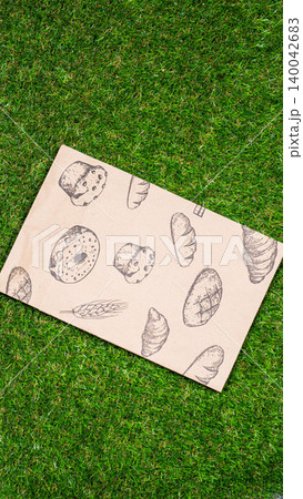 brown paper bag on Green Bush Trees Foliage Background. Eco Nature Friendly Style,Go to zero waste ecological shopping bag on the green grass. An alternative to disposable packages. Zero waste concept brown paper bag on Green Bush Trees Foliage Background. Eco Nature Friendly Style,Go to zero waste ecological shopping bag on the green grass. An alternative to disposable packages. Zero waste concept 140042683