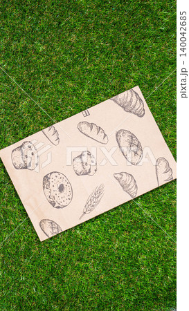 brown paper bag on Green Bush Trees Foliage Background. Eco Nature Friendly Style,Go to zero waste ecological shopping bag on the green grass. An alternative to disposable packages. Zero waste concept 140042685