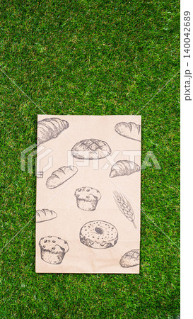 brown paper bag on Green Bush Trees Foliage Background. Eco Nature Friendly Style,Go to zero waste ecological shopping bag on the green grass. An alternative to disposable packages. Zero waste concept brown paper bag on Green Bush Trees Foliage Background. Eco Nature Friendly Style,Go to zero waste ecological shopping bag on the green grass. An alternative to disposable packages. Zero waste concept 140042689