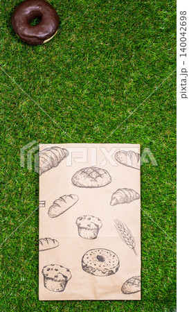 Freshly baked donuts and crumpled paper bag on a grass background .Top view. Freshly baked donuts and crumpled paper bag on a grass background .Top view. 140042698