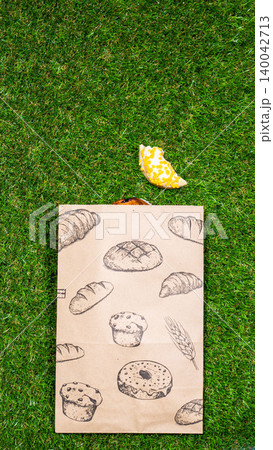 Freshly baked donuts and crumpled paper bag on a grass background .Top view. Freshly baked donuts and crumpled paper bag on a grass background .Top view. 140042713