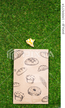 Freshly baked donuts and crumpled paper bag on a grass background .Top view. Freshly baked donuts and crumpled paper bag on a grass background .Top view. 140042714