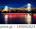 潮風公園からクロスフィルターで輝くレインボーブリッジと屋形船の赤い光跡を捉えた美しい夜景写真 140042824