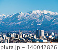 呉羽山から望遠レンズで捉えた富山市街地と残雪の雄大な立山連峰が美しい横位置の昼間風景写真 140042826