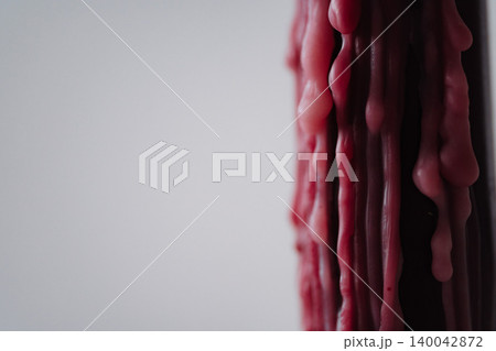 Closeup of melted red wax texture on light background Closeup of melted red wax texture on light background 140042872
