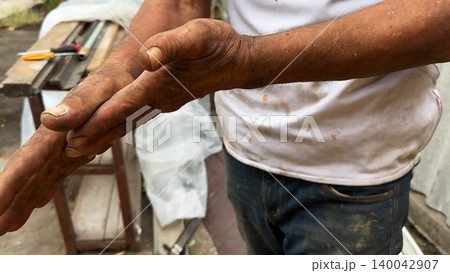 Close up of male dirty hands of adult labor at construction. Repairman rubbing unclean arms after hard work at the site. Concept of exhausting and hard work. Slow motion Close up of male dirty hands of adult labor at construction. Repairman rubbing unclean arms after hard work at the site. Concept of exhausting and hard work. Slow motion 140042907