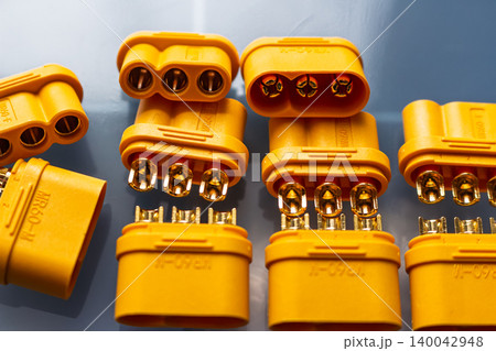 Vibrant yellow MR60 power connectors, male and female, for motor wiring. Shiny gold-plated contacts detailed in a close-up shot. Essential electrical components Vibrant yellow MR60 power connectors, male and female, for motor wiring. Shiny gold-plated contacts detailed in a close-up shot. Essential electrical components 140042948