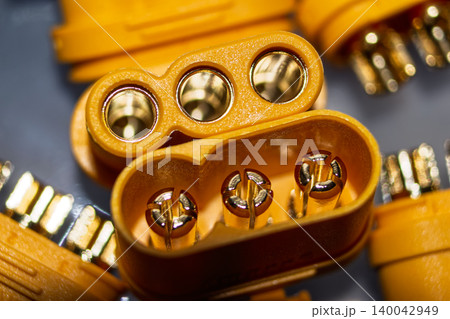 Macro shot of vibrant yellow MR60 power connectors. Glistening gold-plated brass pins and sockets for robust three-phase electric motor and EV applications 140042949