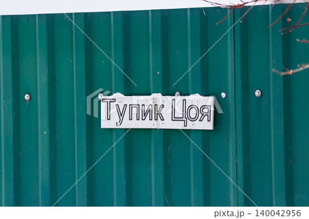 Unique Tsoi's Dead End street sign on a rustic green fence, hinting at a distinct Russian suburban vibe in winter: Kaluga region, Russia Unique Tsoi's Dead End street sign on a rustic green fence, hinting at a distinct Russian suburban vibe in winter: Kaluga region, Russia 140042956
