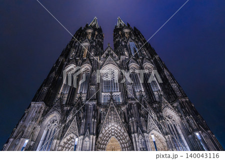 Illuminated Cologne Cathedral facade at night with dramatic gothic towers  140043116