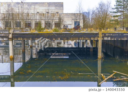 Abandoned industrial ruin. Deserted warehouse interior features flooded floors and peeling paint surfaces 140043330