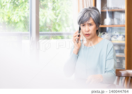 自宅でスマホ通話するシニア女性 140044764