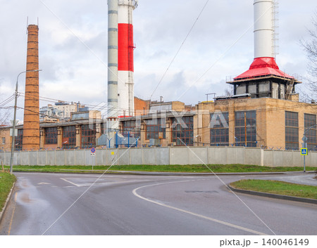 Curved pathway directs gaze toward factory structures with smokestacks and industrial skyline Curved pathway directs gaze toward factory structures with smokestacks and industrial skyline 140046149