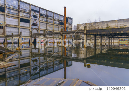 Industrial decay reflected. Aged industrial space with water reflections and weathered structures Industrial decay reflected. Aged industrial space with water reflections and weathered structures 140046201
