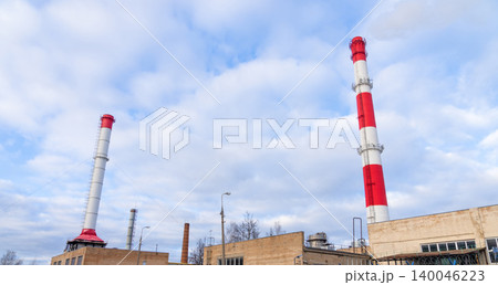 Cityscape with factories. Vertical industrial structures form rhythmic pattern beneath overcast clouds Cityscape with factories. Vertical industrial structures form rhythmic pattern beneath overcast clouds 140046223