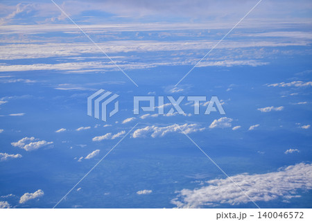 Looking through the airplane window with the view of cityscape under the clouds. Clouds above the city. Looking from aerial view. Nature and travel concept. Looking through the airplane window with the view of cityscape under the clouds. Clouds above the city. Looking from aerial view. Nature and travel concept. 140046572